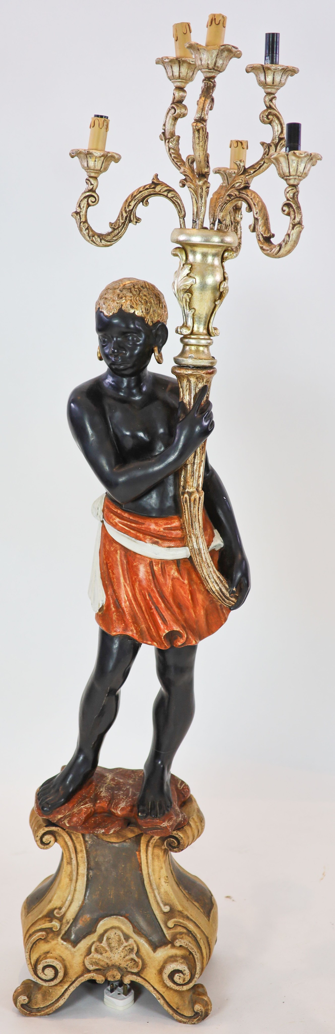 An 18th century style Venetian design polychrome painted carved wood blackamoor figure, poised as a six light candelabrum, height 169cm